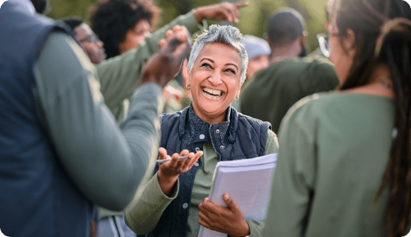 A joyful employee interacting with her fellow workers in a warm and upbeat environment.